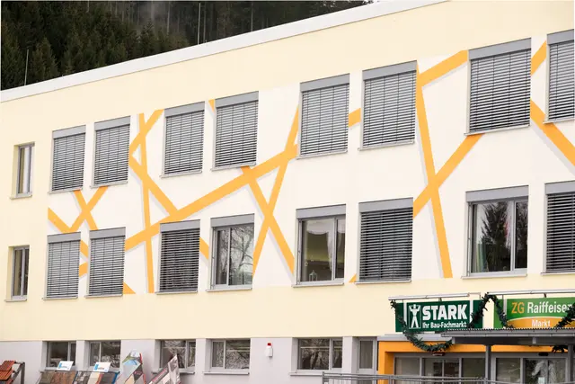 Gebäudefassade mit gelbem Diagonalmuster