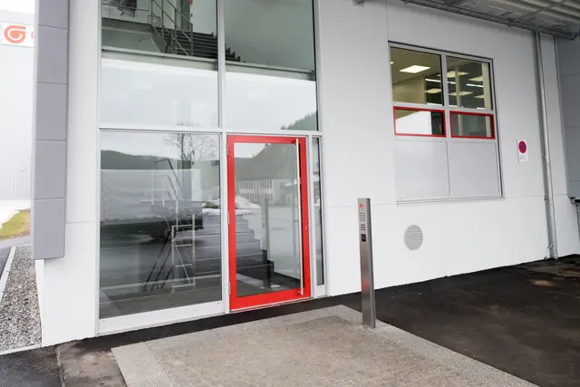 Rot gerahmtes Fenster in einer Industriefassade
