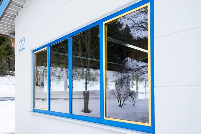 Farbig gerahmte Fensterfront an einem Schulgebäude