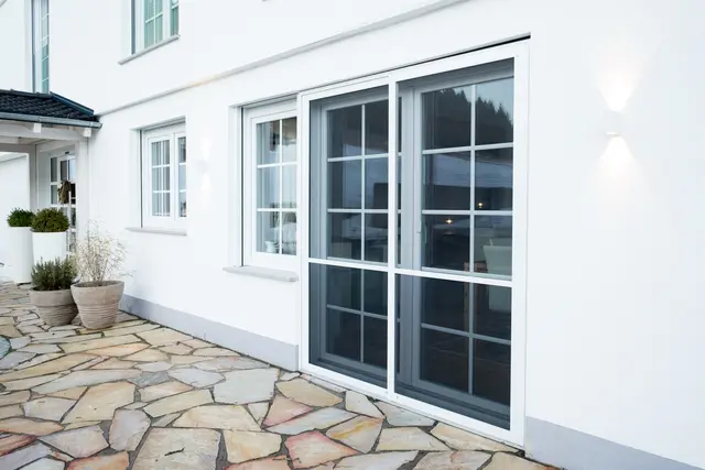 Fensterfront mit Terrassenzugang und Natursteinboden