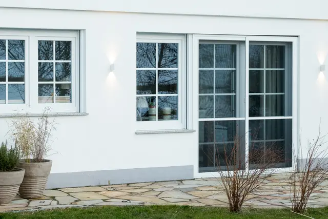 Beleuchtete Fensterfront an einem Wohnhaus