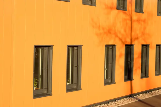 Fensterreihe in einer orangefarbenen Putzfassade