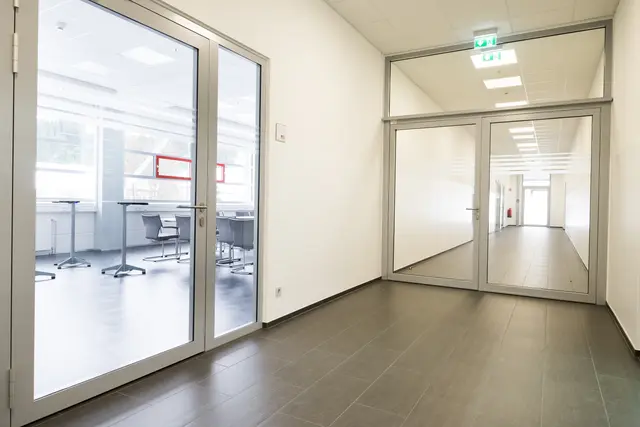 Heller Flur mit verglasten Türelementen