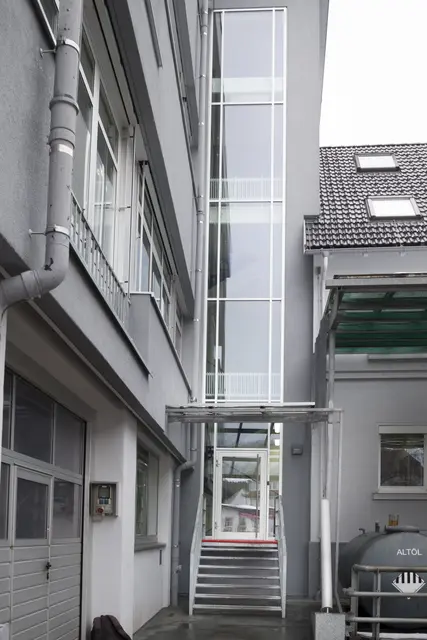 Grauer Gewerbebau mit Fensterbändern