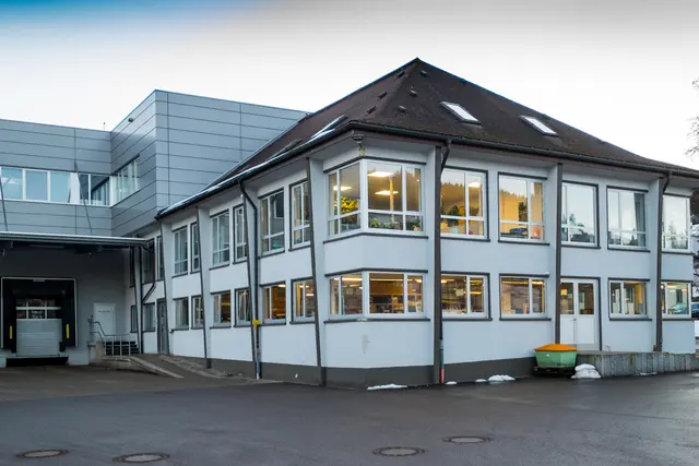 Beleuchtete Glasfassade eines Bürogebäudes am Abend