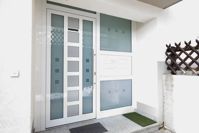 Weiße Haustür mit dekorativem Glaseinsatz
