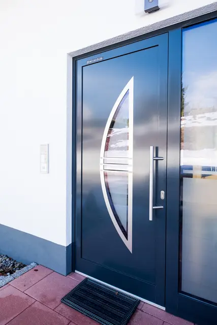 Moderne anthrazitfarbene Haustür mit langem Edelstahlgriff