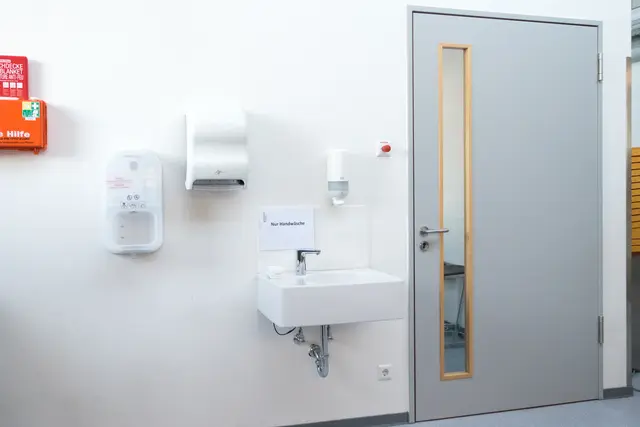 Innentür zu einem Sanitärraum mit heller Wandverkleidung