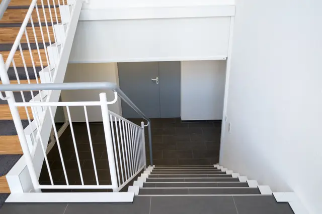 Treppenhaus mit Holzstufen und Metallgeländer
