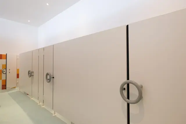 Helle WC-Trennwandanlage mit schwarzen Beschlägen